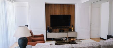 En moderne stue med en sofa, et sofabord, en lampe og et fjernsyn.
