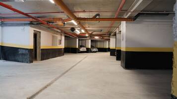 A multi-level parking garage with concrete floors and walls, featuring yellow and black stripes.