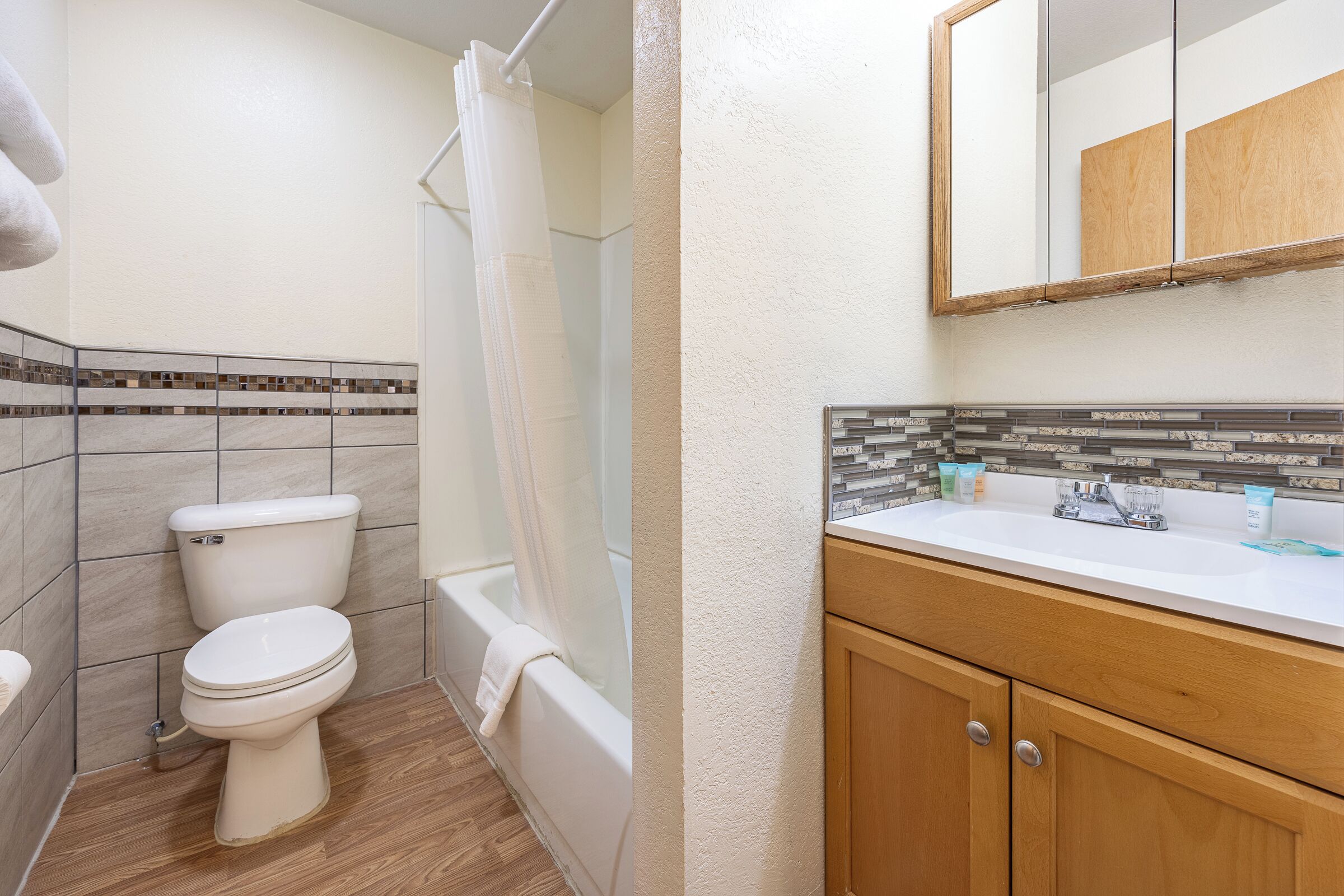 A bathroom with a toilet, bathtub, and sink.