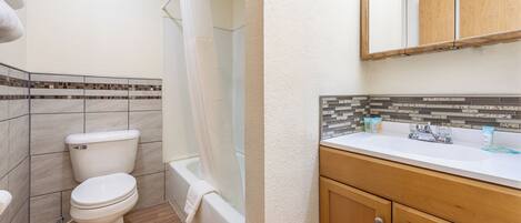 A bathroom with a toilet, bathtub, and sink.