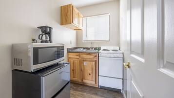 A compact kitchen with a microwave, stove, and refrigerator.