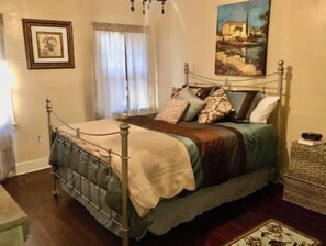 Cozy retreat with a metal-framed bed, wooden floor, and a side table.