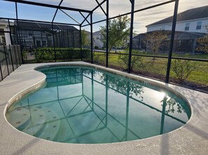 A swimming pool with a clear view of the surrounding neighborhood, including houses and greenery. - Lovely Villa at Kissimmee (Kissimmee)