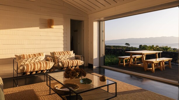 A modern interior with a sofa set, a glass coffee table, and a dining area with wooden furniture. - Casas da Prainha   A (Prainha de Baixo)