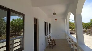 A corridor with white walls, wooden chairs, and a ceiling light fixture. - Dacha Diani Paradise 2 (Diani)