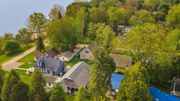 A residential area with houses, a clear view of the sea, and a well-maintained lawn.