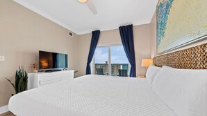 Habitación de hotel con una cama grande, televisión de pantalla plana, escritorio y ventana con cortinas.