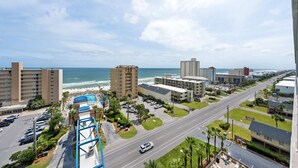 Un paisaje urbano costero con edificios altos, una playa y una carretera.