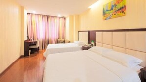 A hotel room with two beds, a desk, a chair, and a painting on the wall. - Greentree Inn Jiangsu Zhangjiagang Jingang Town Darunfa Express Hotel (Suzhou)