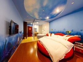 Quarto com cama, televisão e banheiro.