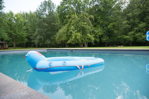 Ein Swimmingpool mit einer blauen Luftmatratze, die auf dem Wasser schwimmt.