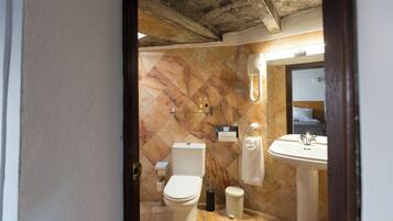 Un baño con inodoro, lavamanos y ducha.