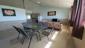 Una sala moderna con comedor, un sofá y un televisor.