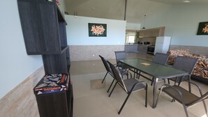 Un comedor moderno con una mesa rectangular, seis sillas y un sofá con cojines estampados.
