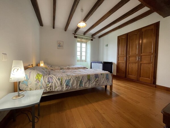 A bedroom with a bed, a desk, a chair, a wardrobe, and a window. - Zamatelua 1 - Sare - Gîte (SARE)