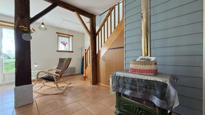 A room with a wooden staircase, a rocking chair, a fireplace, and a window with a view. - LE Mouly/petit Gite - Miossens-lanusse (MIOSSENS-LANUSSE)
