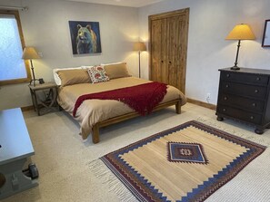A bedroom with a bed, two bedside lamps, a wooden wardrobe, a rug, and a painting on the wall. - Crested Butte Home | 4 Bedroom | Hot Tub | Walk to Elk | Gas Grill |Pet-Friendly (Crested Butte)