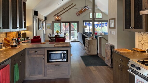 A modern kitchen with a built-in microwave, wooden cabinets, and a central island. - Crested Butte Home | 4 Bedroom | Hot Tub | Walk to Elk | Gas Grill |Pet-Friendly (Crested Butte)