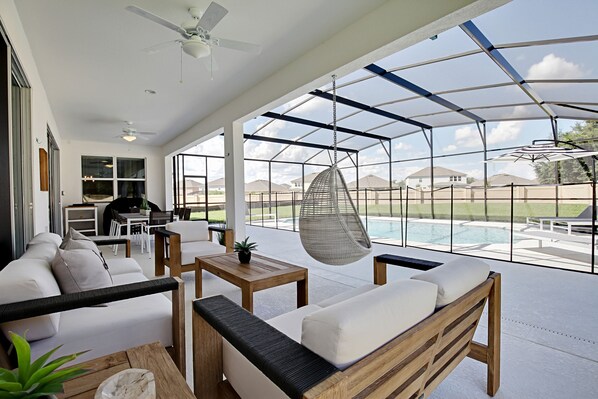 Relax in a comfortable seating area with a sofa and table, overlooking the outdoor pool.