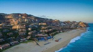 A coastal resort with beachfront villas, a swimming pool, and a beach.