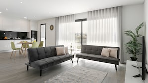 A modern living room with two sofas, a dining area, and a kitchen.