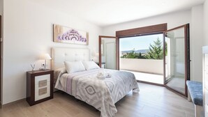 A bedroom with a bed, bedside table, and a view of the outdoors through a sliding glass door. - Aromas de Alcala Alcalá La Real by Ruralidays (Jaén)