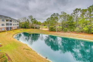 A residential building with a swimming pool, surrounded by trees and a grassy area. - Golf Resort Condo w/ Pool in North Myrtle Beach! (North Myrtle Beach)
