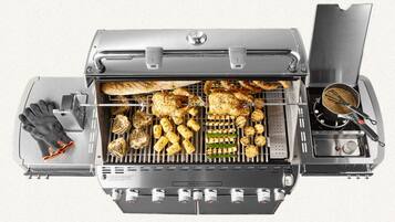 Un barbecue doté d’un couvercle, d’un brûleur latéral et d’un thermomètre intégré.