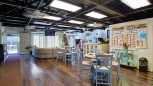 An office with wooden flooring, round tables, and chairs. There is a Christmas tree and a bulletin board with papers. - Outer Banks Beach Club II - 1BR/1BA - Great Pools! (Kill Devil Hills)