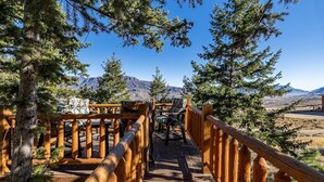 Una escalera de madera que lleva a una terraza con vistas a las montañas.