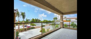 Ein Balkon mit Blick auf einen Parkplatz und benachbarte Gebäude.