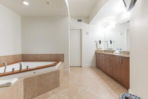 Une salle de bain moderne avec une baignoire sur pieds, un meuble-lavabo et un grand miroir.