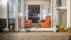 Un intérieur moderne, comprenant un coin repas, deux fauteuils en cuir et des plantes en pot.
