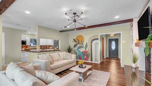 Una sala moderna con un sofá, una mesa de centro y una decoración en la pared.