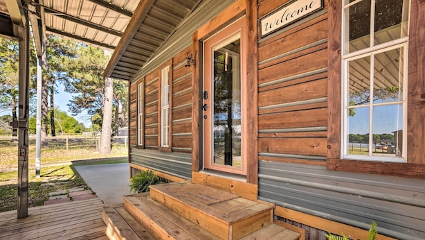A wooden cabin with a porch, a welcome sign, and a view of the surrounding landscape. - Rooftop Deck + Lake Cabin w/ Swim-Dock (Willis)