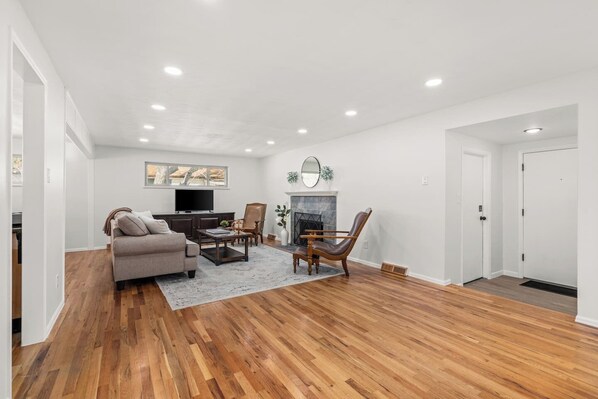 A spacious living room with a fireplace, a television, and a sofa.