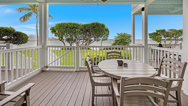 A covered outdoor patio with a table and chairs, a ceiling fan, and a view of trees and a white building. - Villa 5028 on Duck Key Boat Slip Available - 2BD 2.5BA (Duck Key)