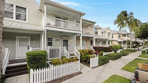 A row of two-story townhouses with balconies, white picket fences, and well-maintained landscaping. - Villa 5028 on Duck Key Boat Slip Available - 2BD 2.5BA (Duck Key)