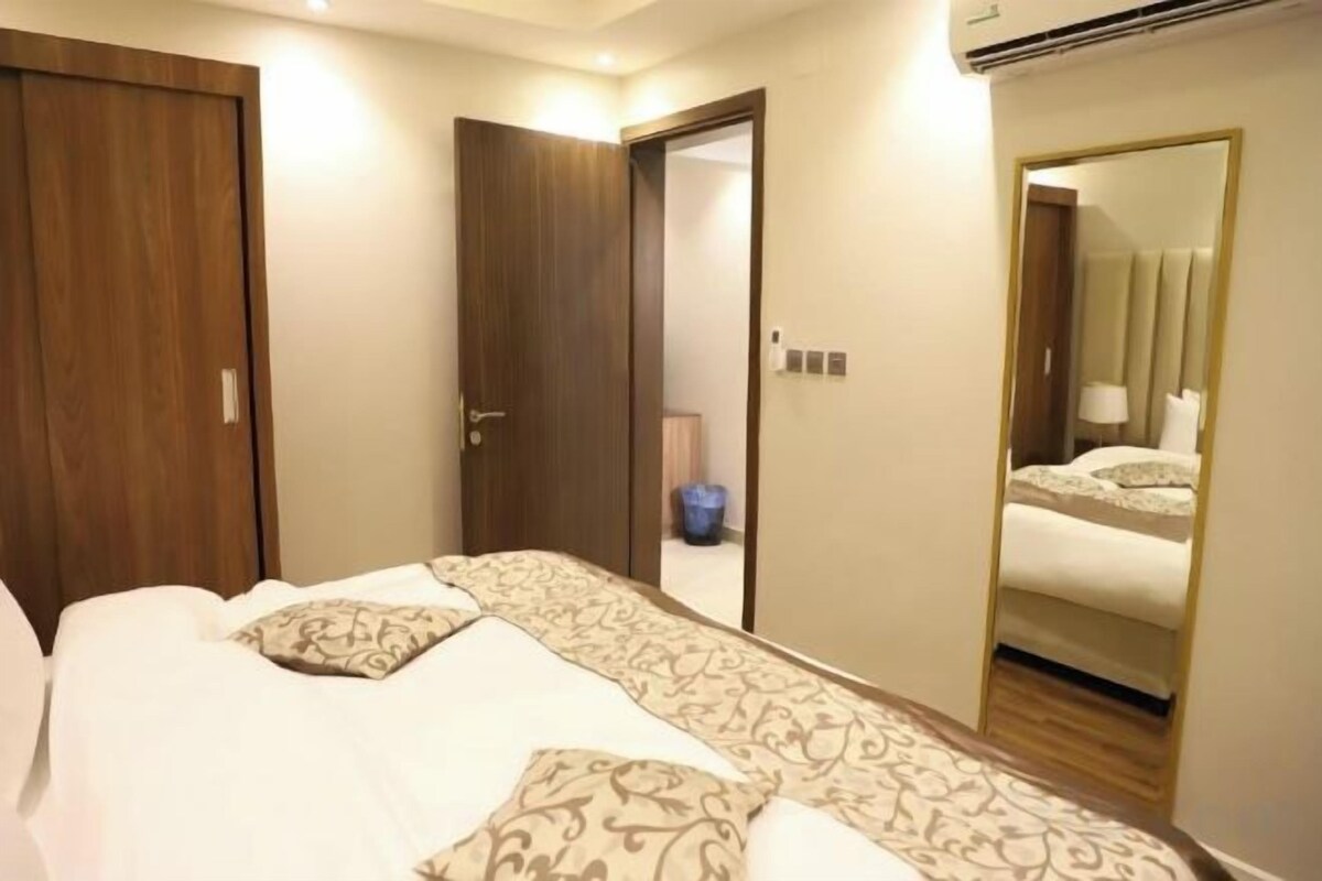 Una camera d'albergo con un letto, un armadio e uno specchio.