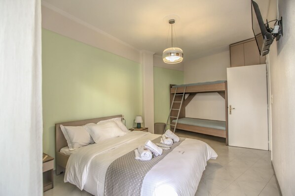 A bedroom with a bunk bed, a bedside table with a lamp, and a wardrobe. - Del Sol 5 Meteora Luxurious Suites  (Kalabaka)
