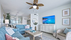 Una sala de estar moderna con un sofá azul, una mesa de centro y muebles de mimbre.