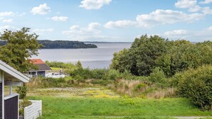 Ett hus med utsikt över en sjö och ett avlägset landskap.