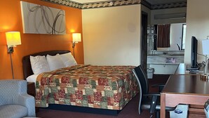 A hotel room with a bed, a desk, a chair, a sofa, and a bathroom visible through an open door. - Lebanon Inn Motel (Lebanon)