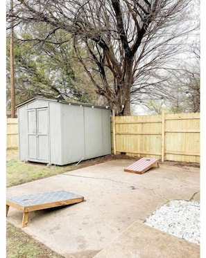 Enjoy the serene backyard with a patio area, wooden fence, and a tree.