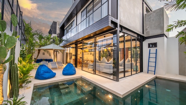 A modern outdoor pool area with a glass-enclosed lounge, seating, and a ladder to the pool. - Private Pool • Daily Housekeeping • Walk to Canggu (Canggu)