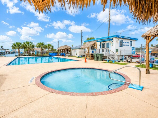 A pool area with two pools, a building labeled 'PARKING LOTS,' and a thatched-roof structure. - Canal | Hot Tub | Large Deck | Private Dock | Pets (Galveston)