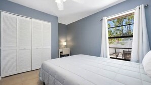 Une chambre à coucher avec un lit, un bureau et une fenêtre avec des rideaux.