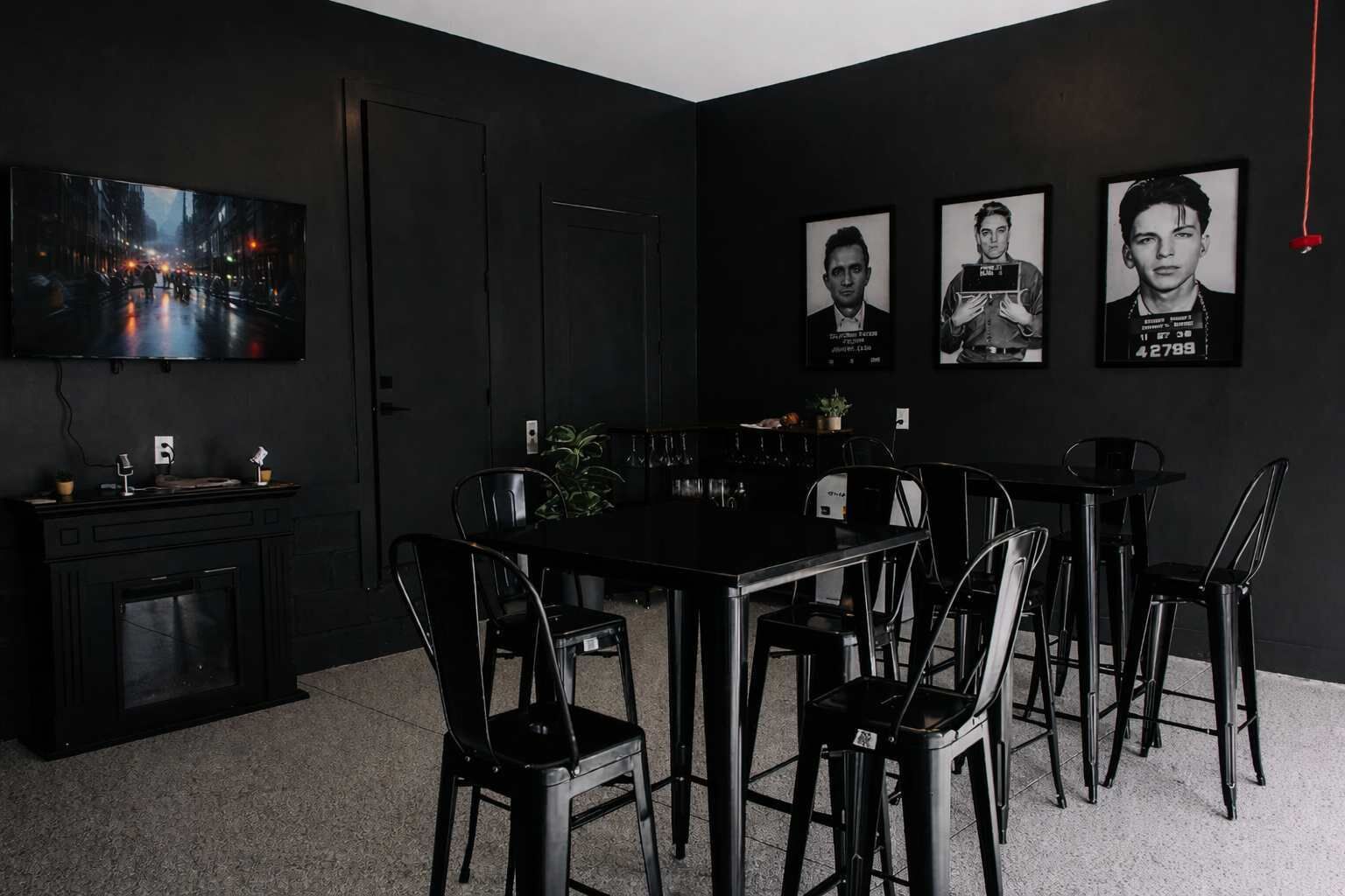 Ein moderner Essbereich mit einem schwarzen Tisch und Stühlen, einem Kamin und einem Stadtbildgemälde.