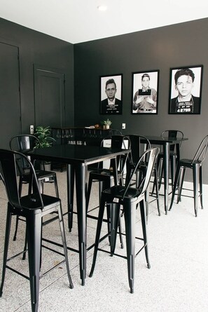 A conference room with a long table, black chairs, and three framed pictures on the wall.