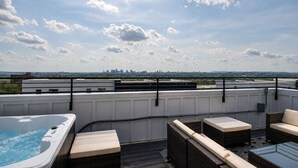 A rooftop terrace with a hot tub, seating area, and a city skyline view. - Nashville Getaway • Hot Tub & Sleeps 12 (Nashville)